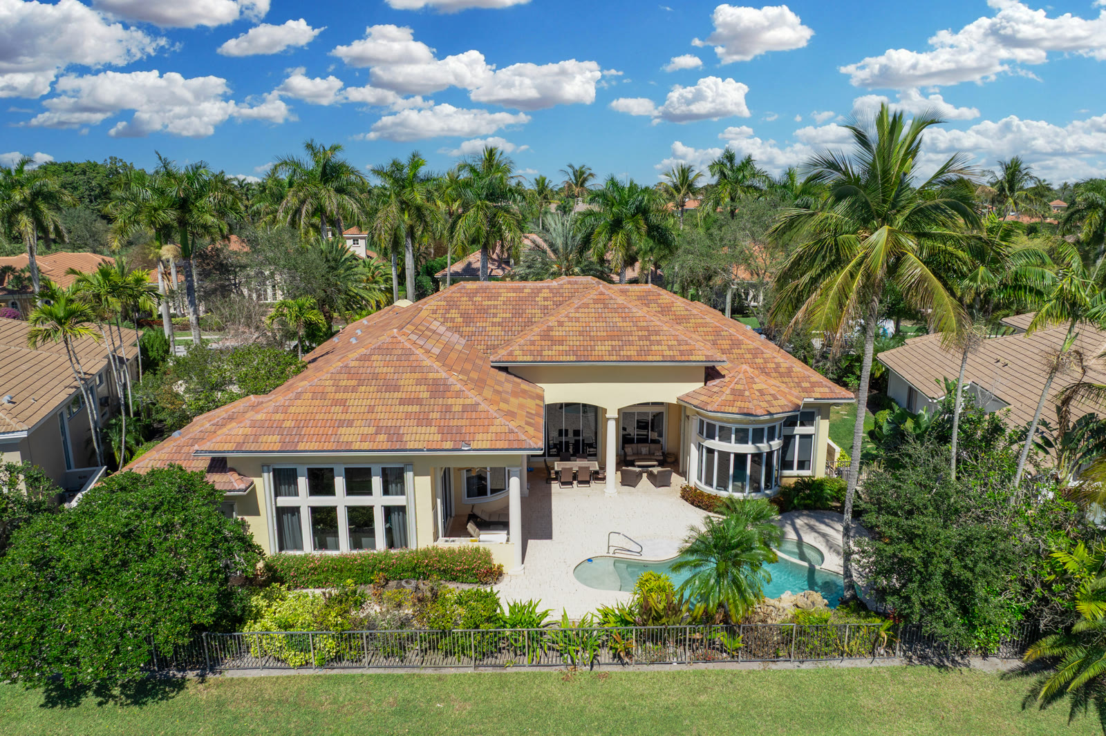 Aerial drone photograph of a luxury home with pool and lush landscaping