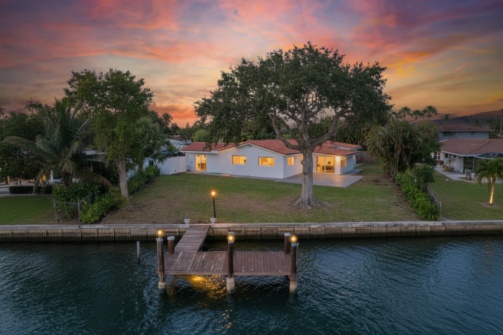 Aerial twilight photograph of a waterfront property at dusk