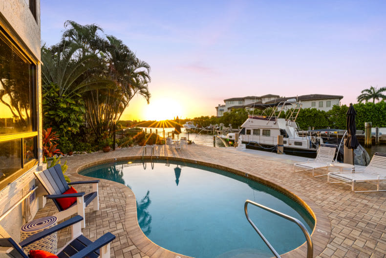 Exterior pool and patio at night in a South Florida luxury home