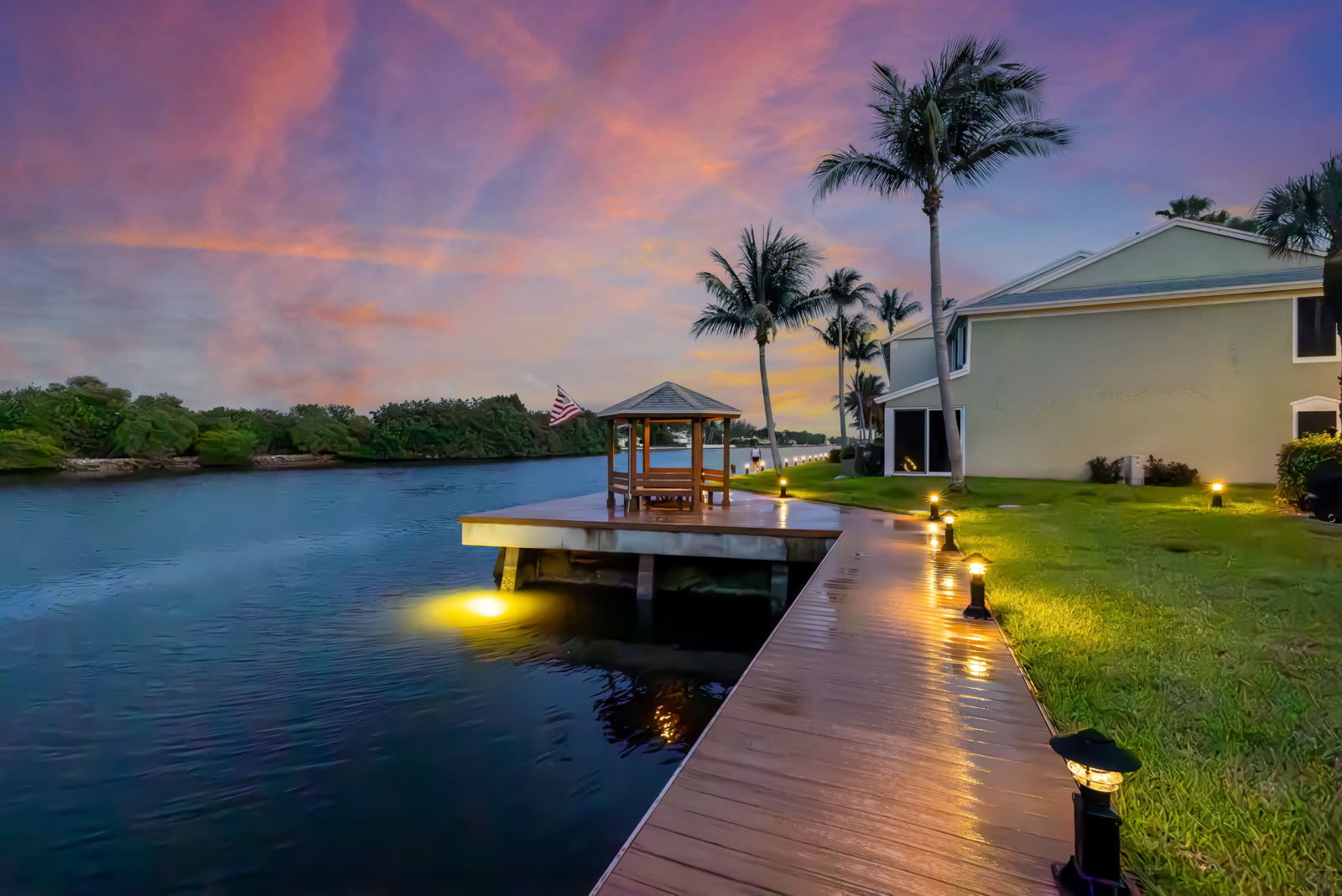 Twilight photograph of a dock and gazebo with American flag at dusk
